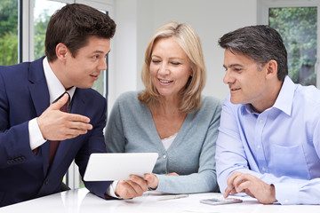 Mature Couple Meeting With Financial Advisor At Home