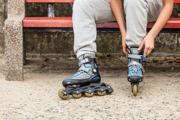 Woman putting on roller skates outdoor.
