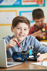 Two Male Pupils In Science Lesson Studying Robotics