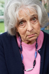 Head And Shoulders Portrait Of Unhappy Senior Woman At Home