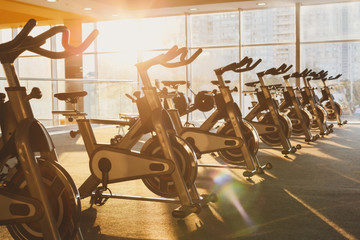 Modern gym interior with equipment, fitness exercise bikes