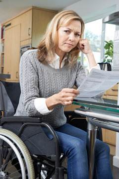 Frustrated Woman In Wheelchair Reading Letter