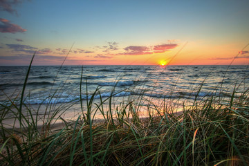 Scenic Summer Sunset Background.  Beautiful sunset horizon over water with a sandy beach and dune...