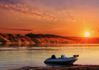 majestic landskape.  fantastic foggy sunset over the river with colorful clouds on the sky. picturesque nature landscape. speed inflatable boat on the river. instagram toning effect,