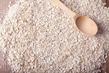 Oat flakes texture with wooden spoon