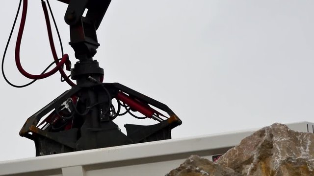 grue avec grappin d&eacute;chargeant un camion

