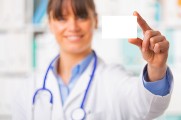 Young female doctor with blank business card
