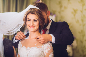 Naklejka premium gorgeous happy luxury stylish brunette bride near a window on the background of vintage room