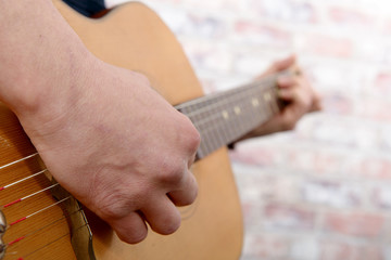 Close-up view of man's hand playing guitar