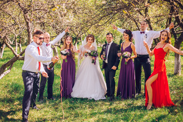 bride and groom with bridesmaids and groomsman having fun anf jump outdoor green park forest