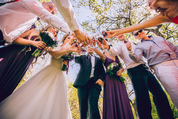 bride and groom with happy groomsmen and bridesmaids having fun and popping champagne, hilarious...