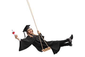Graduate student holding diploma and swinging on swing