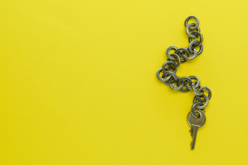 Small Key with a chain on a yellow background