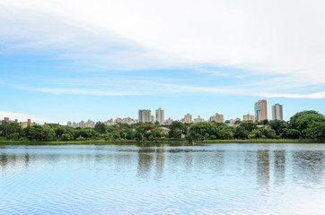 Fototapeta na wymiar Lake reflecting on the water the city and the blue sky. Margins of the lake Igapo in Londrina, PR, Brazil.