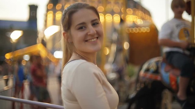 Happy smiling woman in amusement park at evening