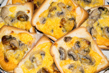 Fette di pancarrè tostate e condite con funghi, formaggio e uovo 