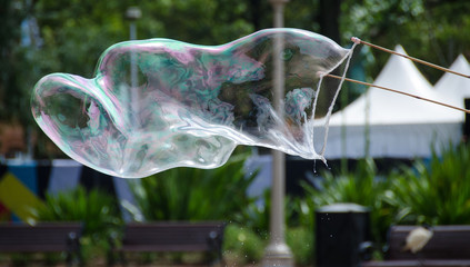 Fototapeta na wymiar Giant soap bubble blowing sideways in wind