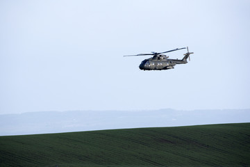 Fototapeta na wymiar A Merlin MK3 Royal Navy helicopter over farmland in Devon England UK. January 2017