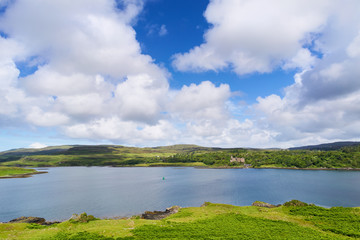 Fototapeta na wymiar Blue skies and white clouds over Dunvegan Loch and Castle on the Isle of Skye, Scotland, UK. 