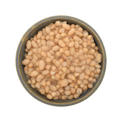 Organic navy beans in a stoneware bowl top view isolated on a white background.