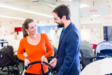Obraz premium Couple in baby shop buying stroller
