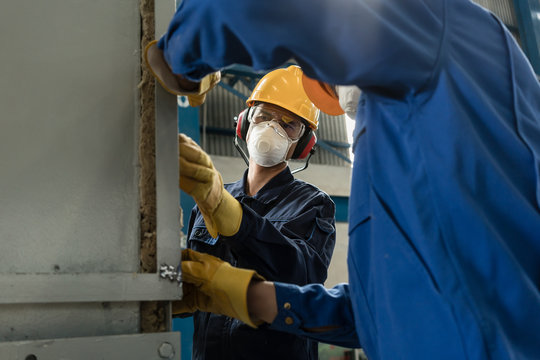 Two blue-collar workers wearing protective equipment