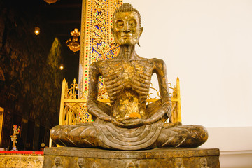 starving Buddha statue with thai art architecture in church Wat Suthat temple. This is a Buddhist temple in Bangkok .
