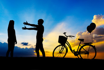Silhouette of sweet couple in love happy time and bicycle in bea
