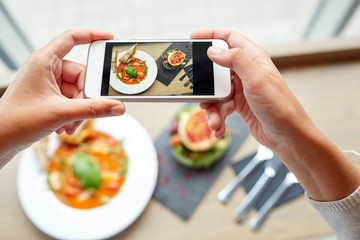 hands with smartphone photographing food