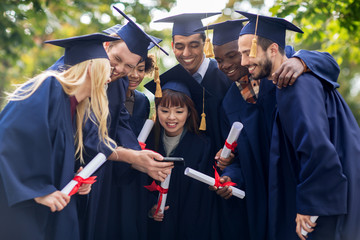 students or bachelors with diplomas and smartphone