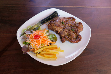 Delicious grilled pork chops steak with french fires and salad w