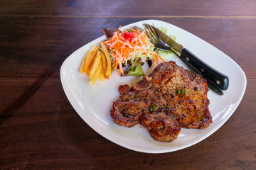 Delicious grilled pork chops steak with french fires and salad w
