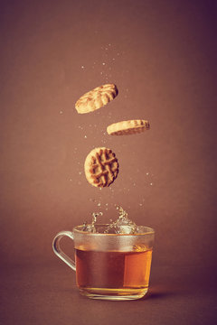 T&egrave; caldo con biscotti che cadono