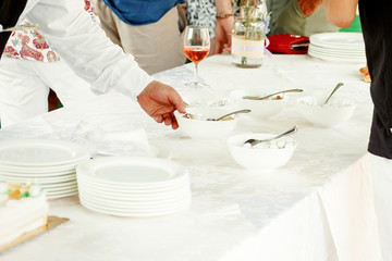 Waiter takes bowl from the table
