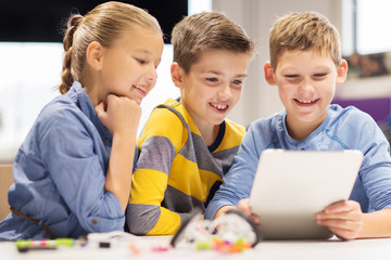 kids with tablet pc programming at robotics school