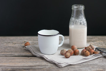 Glass of hazelnut milk on wooden background