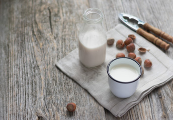 Glass of hazelnut milk on wooden background