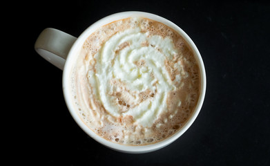Top view mocha with whipped cream in coffee mug  on black table background