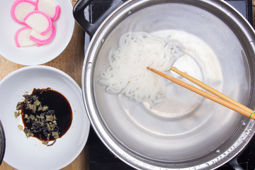 Chef scald udon noodle in pot