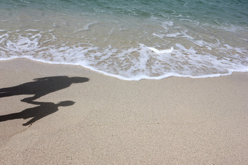 Shadow of a mother and daughter on the beach near the sea. 