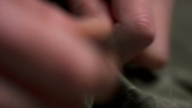 A woman unstitching the cloth using the sharp scissors macro closeup slow motion