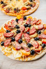 Top view two Pizza with mushrooms, olives and tomatoes, sausage. Rosemary and fresh vegetables. Freshly homemade