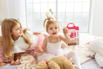 Happy girls playing in bedroom