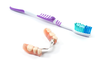 Partial denture with toothbrush isolated on white