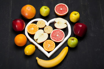 Fruits and heart on black background