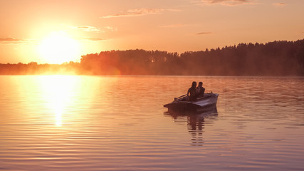 Romantic golden sunset river lake fog loving couple small rowing boat Romantic date beautiful...