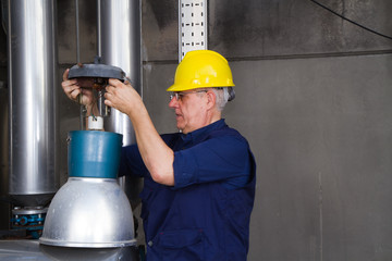 electrician repairing street lamps in a industrial site