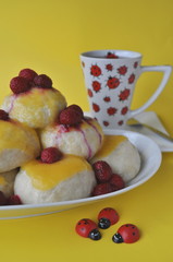 Nicely served Central European dessert of sweet steamed dumplings (an alternative version of Austrian Germknoedel) with hot fruit sauce on a colorful background

