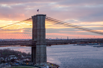 Naklejka premium Colorful sunset behind Brooklyn Bridge, Manhattan New York City