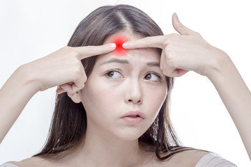 Naklejka premium Asian woman squeezing glowing red spot on forehead
